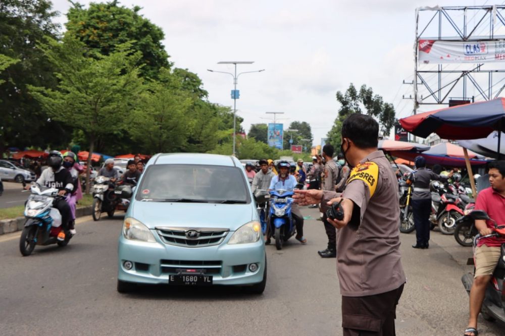 Kapolres Bungo, AKBP Guntur Saputro mengatur lalu lintas secara langsung di Jalan Lintas Sumatera, Depan Pasar Bungur, Muarobungo. (Foto: ist)