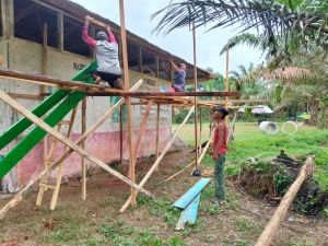 Bersama Satgas TMMD, Warga Gotong Royong Pasang lisplang Madrasah Nurul Falah